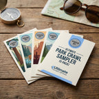 Five scratch-off cards from 'Ultimate Park Crawl Sampler' on a wooden surface with a map, sunglasses, and compass in the background.